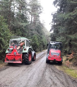 Wege freischneiden in Wolthausen und Wittbeck 2025 Zwei Traktoren auf einem Waldweg, umgeben von dichtem Wald.