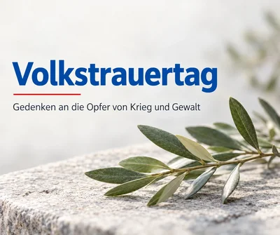 Olivenzweig auf einem Granitblock. Daneben der Text „Volkstrauertag – Gedenken an die Opfer von Krieg und Gewalt“.