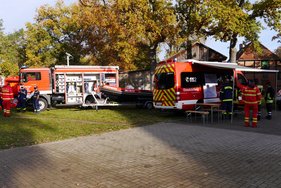 Hochwasseraktionstag Rote Feuerwehrfahrzeuge und Rettungskräfte bei einer Übung im Freien.