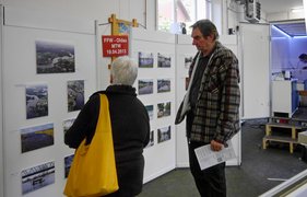 Hochwasseraktionstag Zwei Personen betrachten eine Fotoausstellung mit Bildern und Infos auf Stellwänden.