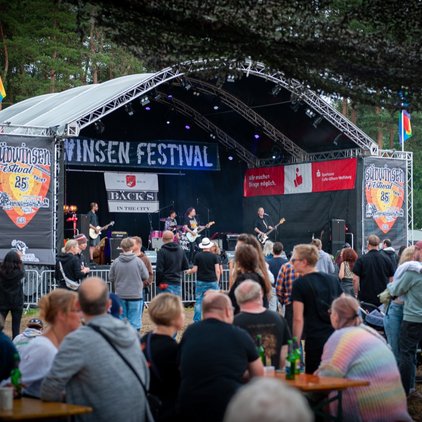 Menschen vor einer Bühne auf einem Festival