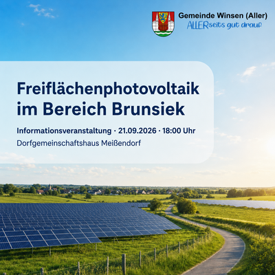 Weitläufige Photovoltaikanlage auf einer Wiese mit Blick auf Wasser und Vegetation. Im Hintergrund sind Gebäude erkennbar.
