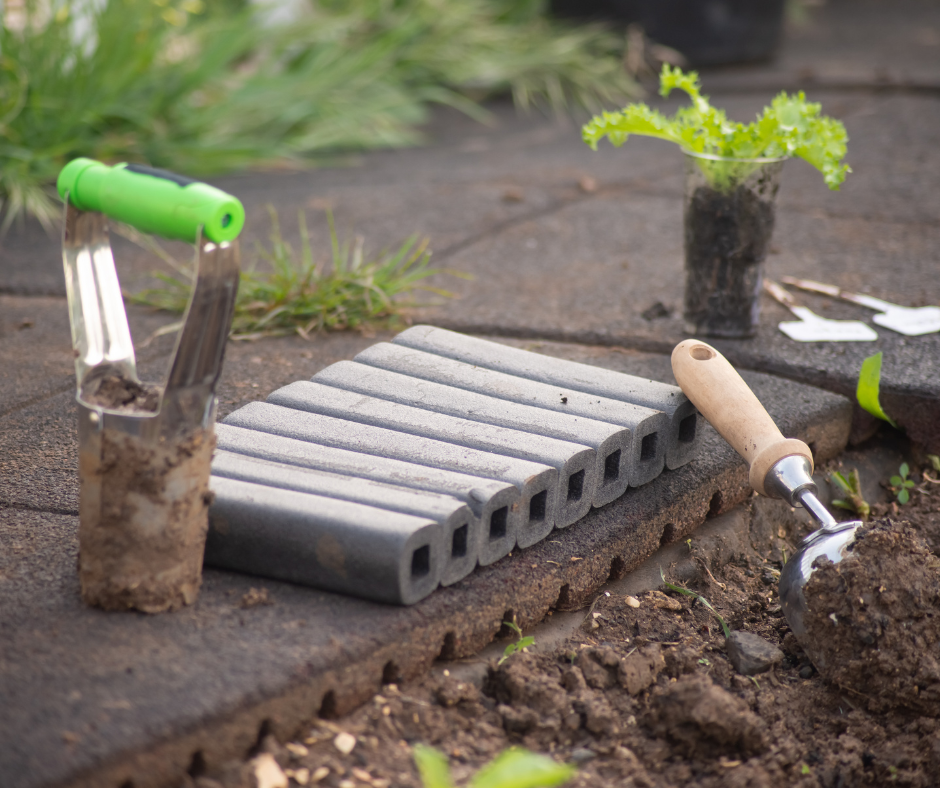 Gartenwerkzeug und Knieschutz am Blumenbeet